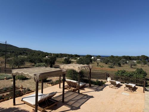 a patio with chairs and umbrellas with a view at Agroturismo Sa Marina - Adults Only in Cala Boix