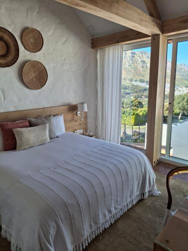 a bedroom with a large bed and a large window at Umoya Residence in Cape Town