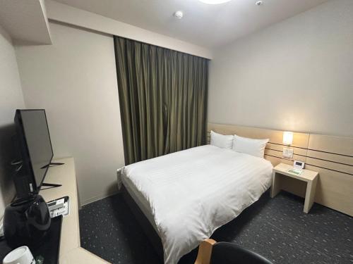 a hotel room with a bed and a television at Dormy Inn Akita in Akita