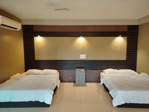 Ένα ή περισσότερα κρεβάτια σε δωμάτιο στο Nara Inn Langkawi