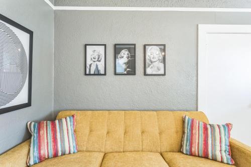 a living room with a couch and four pictures on the wall at Retro Revival with Modern Luxury home in Gonzales