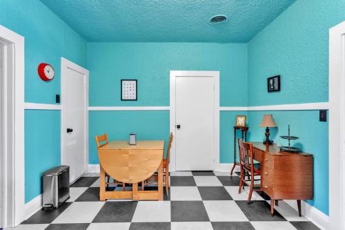 a dining room with blue walls and a table and a desk at Retro Revival with Modern Luxury home in Gonzales