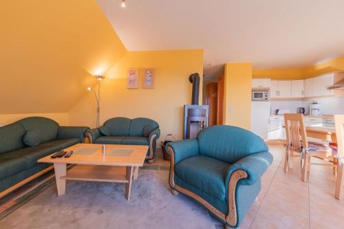 a living room with two couches and a table at Ferienwohnung Storchenhorst - gemütliches Apartment mit Kamin in Göhren-Lebbin
