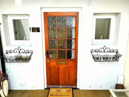 a wooden door on a white house with two windows at Gorgeous Apartment near Bournemouth Beach in Bournemouth