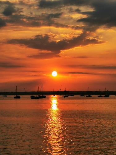 a sunset over a body of water with boats at Gorgeous Apartment near Bournemouth Beach in Bournemouth