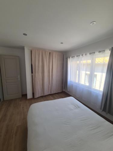 アルジュリエにあるJolie T4 rénové avec balcon-terrasseの白いベッドと窓のある寝室