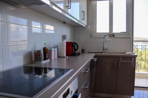a kitchen with a counter and a sink and windows at Gabi's Nest in Chalkida