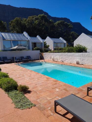 a swimming pool in front of a house at Umoya Residence in Cape Town