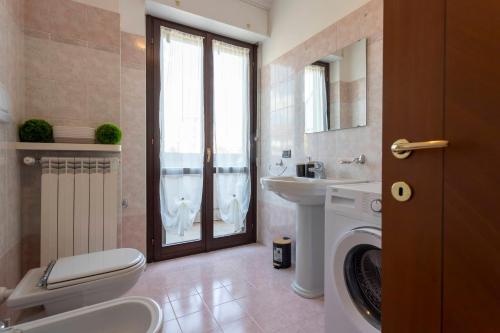 ein Badezimmer mit Toilette, Waschbecken und Waschmaschine in der Unterkunft Novara Smart Stay - Station, AC & 2Gb s Wi-Fi in Novara