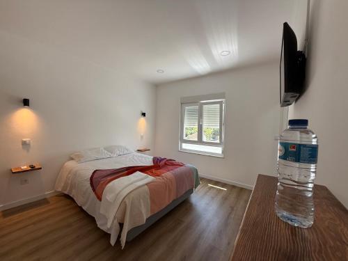 a bedroom with a bed and a bottle of water at 5Melros in Santiago do Cacém