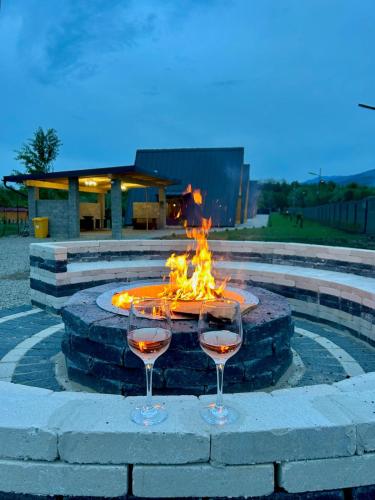 two glasses of wine in front of a fire pit at A Frame Bâlea Chalet in Cîrţişoara