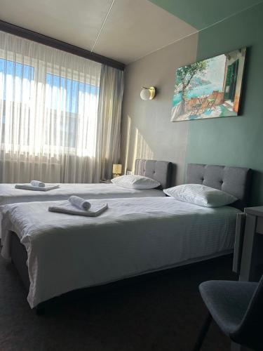 a hotel room with two beds and a window at Hotel Vento in Ventspils