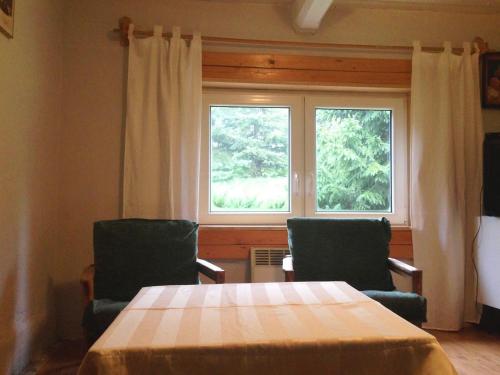 a room with two chairs and a table and a window at Chatka na Lipowych Wzgórzach in Marcówka