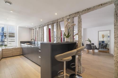 une cuisine avec un comptoir et un bar avec un tabouret dans l'établissement Ecarlate, à Paris