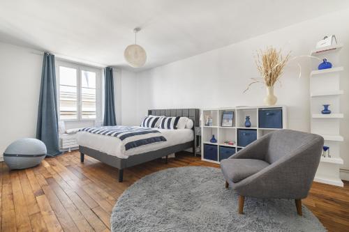 une chambre avec un lit, une chaise et un canapé dans l'établissement Ecarlate, à Paris