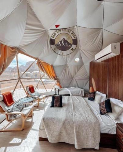 a bedroom with a bed and chairs in a tent at WADI RUM DESERt MOON in Wadi Rum