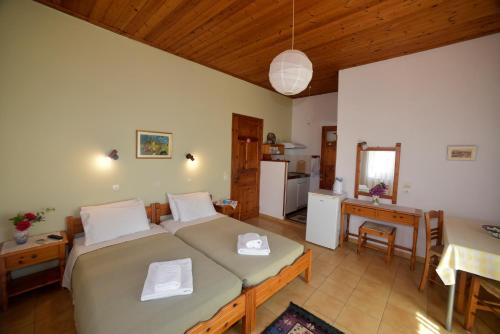 a large bedroom with two beds and a kitchen at Evanthia Toroz Rooms & Studios in Mithymna