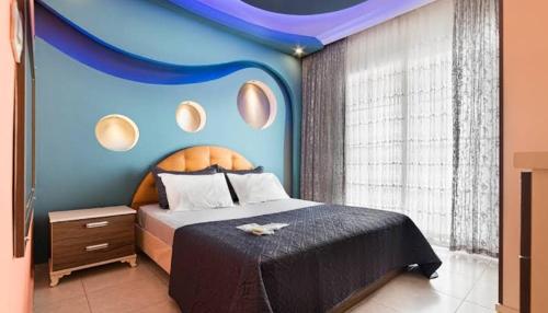 a bedroom with a bed with a blue wall at Loft Suit Apart Otel in İskenderun