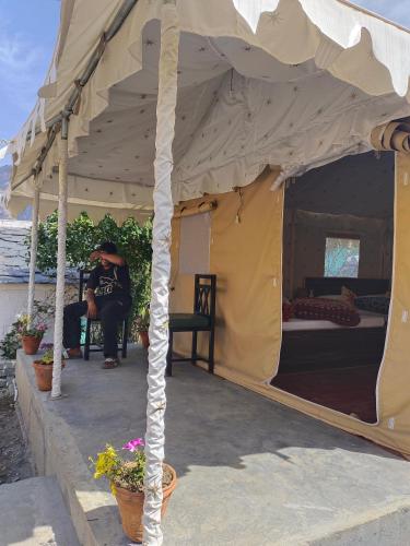 a person is sitting in a tent at Shakoon Camps & Farmstay Nainital in Nainital