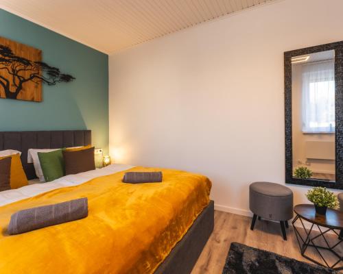 a bedroom with a large bed with a yellow blanket at Ezerjó Házikó in Nyúl