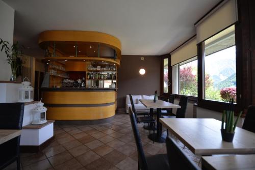 a restaurant with tables and chairs and a bar at Hotel Sorriso in Ponte di Legno