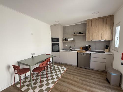 a kitchen with a table and chairs in a room at 5Melros in Santiago do Cacém