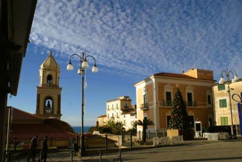 a group of buildings with a clock tower and a church at Bellezza In Cilento Panoramic Apts in Castellabate