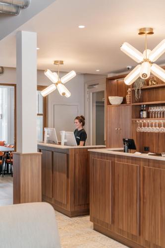 a woman standing at a reception desk in a lobby at Malie House in Utrecht