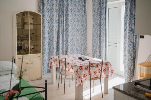 a kitchen with a table and chairs with blue curtains at Residence Riviera in Palinuro