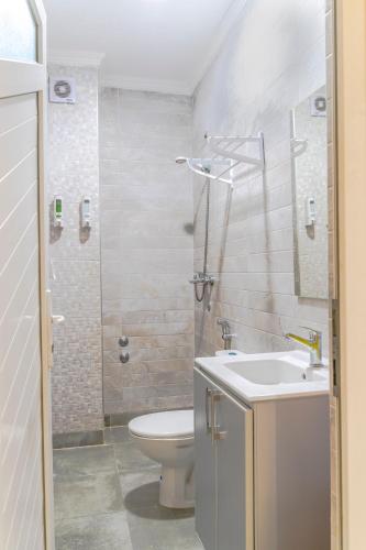 a bathroom with a toilet and a sink and a shower at Appart hotel tanger in Dakhla