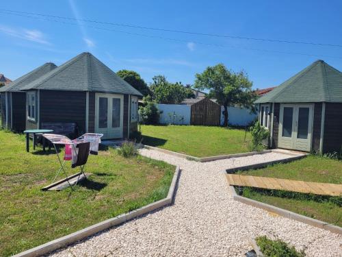 a yard with two houses and a house with a grill at The Vie Llage - Authorial Suites Bungalows in Vagos
