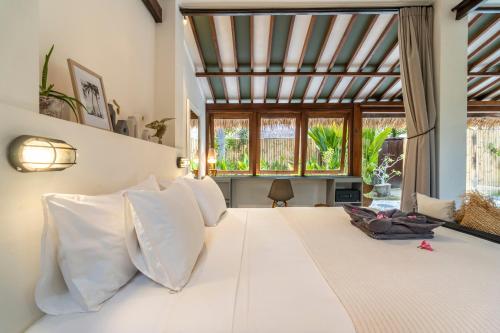 a bedroom with a large bed with white pillows at Villa Maiya - Charming 1-Bedroom Villa with Pool in Gili Islands