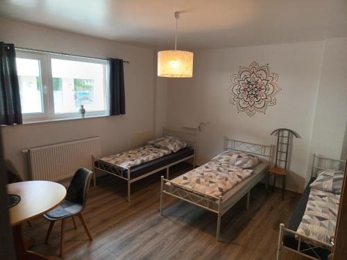 ein Zimmer mit zwei Betten und einem Tisch und einem Fenster in der Unterkunft 1-ZApp "TRENDHAUS-1" Zentrum! in Hofgeismar