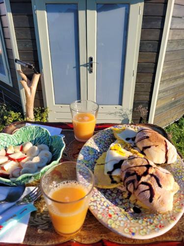 a table with plates of food and glasses of orange juice at The Vie Llage - Authorial Suites Bungalows in Vagos