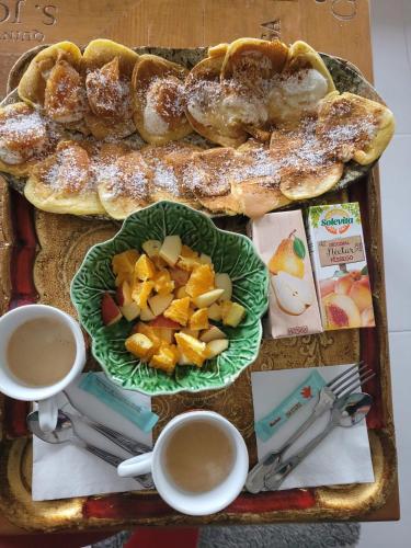 a table with a tray of pastries and cups of coffee at The Vie Llage - Authorial Suites Bungalows in Vagos