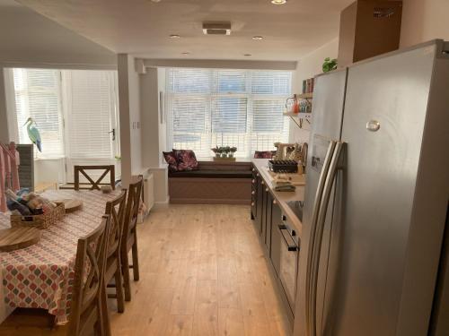 a kitchen with a refrigerator and a table with chairs at Blacksands Seaview Cottage, Aberdour in Aberdour
