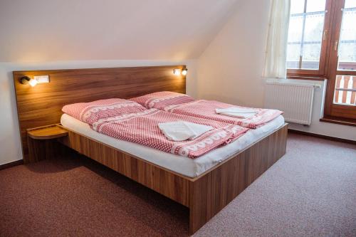 a bedroom with a bed with a wooden headboard at Penzion Pribisko in Zuberec