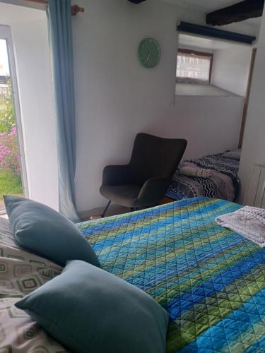 a bedroom with a bed and a chair and a window at Bethesda Plouasne - family friendly B&B, countryside location in Plouasne