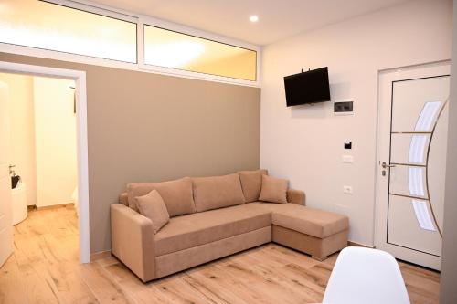 a living room with a couch and a tv at Swiss Lux apartments in Durrës