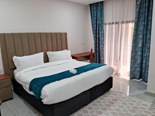 a bedroom with a large bed with a teddy bear on it at Kalundu Conference Centre in Lusaka