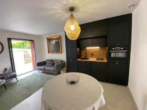 - une cuisine avec des armoires noires et une table dans une pièce dans l'établissement La maison de Flassan chic et sport, à Flassan