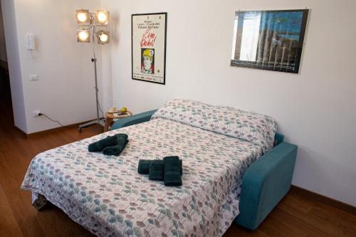 a bedroom with a bed with two black slippers on it at Gli Ippocastani - Free Parking - Old Town - Elegant & Spacious in LʼAquila