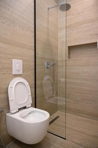 a bathroom with a toilet and a glass shower at Swiss Lux apartments in Durrës