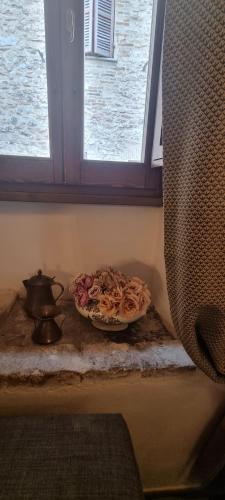 a plate of roses on a table under a window at Domus Hispellum in Spello