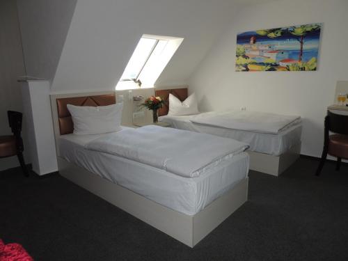 2 Betten in einem Hotelzimmer mit weißer Bettwäsche in der Unterkunft Gasthof Kessler in Oberthulba