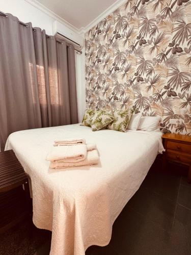 a bedroom with a bed with towels on it at Apartamento Bajondillo Cozy Inns in Torremolinos