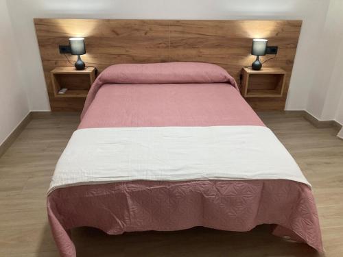ein Schlafzimmer mit einem Bett mit zwei Lampen auf zwei Tischen in der Unterkunft El Rincón de Elena II in Cazorla