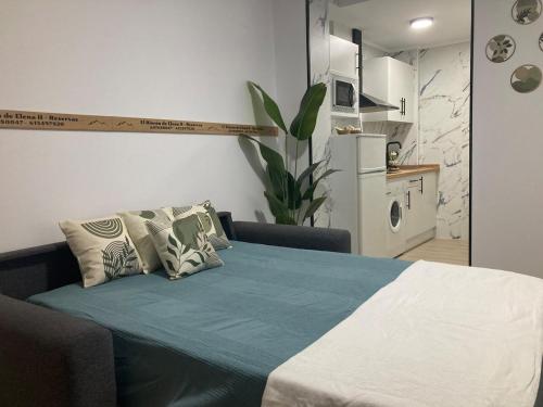 ein Schlafzimmer mit einem Bett mit einer Couch und einer Küche in der Unterkunft El Rincón de Elena II in Cazorla