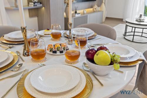 una mesa con platos de comida y un bol de fruta en Boho Bayfront 1BR in La Sirene 2 Seaport View, en Dubái