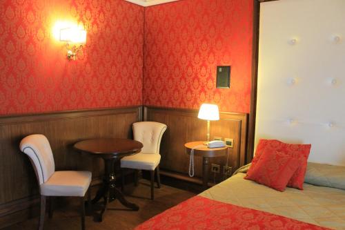 a hotel room with a bed and a table and chairs at Hotel La Rosa Dei Venti in Campogrande